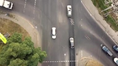 Şehir trafiğinin yukarıdan aşağıya bakan görüntüsü, kavşaktaki bir caddede hareket halindeki arabalar..