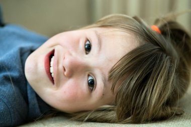 Portrait of a pretty child girl laying down at home.