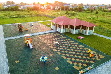 Çocuk aktiviteleri için kırmızı kiremitli çatısı olan anaokulundaki yeni oyun bahçesinin havadan görünüşü.