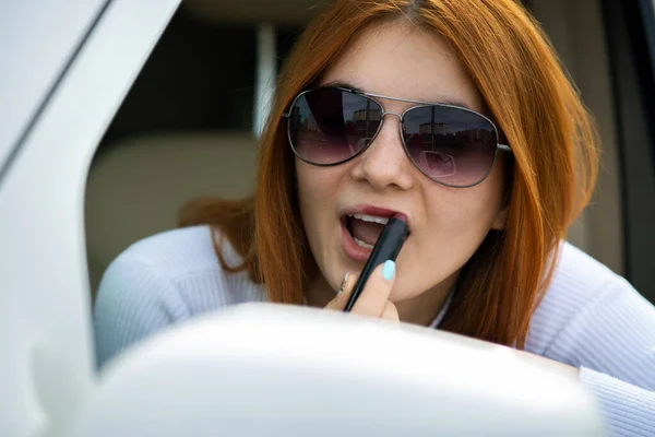 Closeup Young Redhead Woman Driver Correcting Her Makeup Dark Red — 스톡 사진