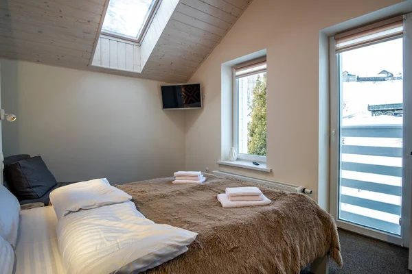 大きなダブルベッドで新鮮なリネンと屋根裏部屋の床に広々としたホテルのベッドルームのインテリア 現代的な家の中の居心地の良い現代的なマンサードルーム — ストック写真