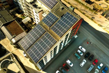 Temiz elektrik üretmek için konut bloğunun çatısındaki güneş fotovoltaik panellerin hava görüntüsü. Özerk konut kavramı.