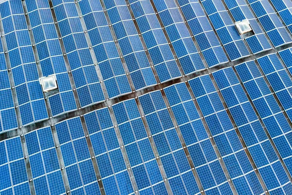 産業用建物の屋根に取り付けられた多くの太陽光パネルの空中ビュー — ストック写真