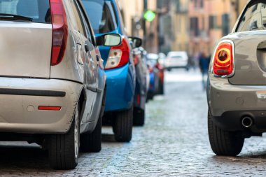 Şehir caddesinin kenarına park edilmiş modern arabalar var. Kaldırımın kenarına park edilmiş parlak araçlar. Kentsel ulaşım altyapı kavramı.