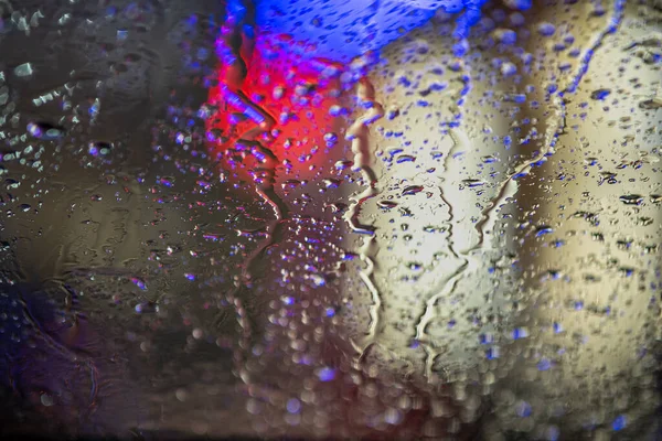 Abstrakter Farbenfroher Hintergrund Der Glasoberfläche Mit Wassertropfen Und Verschwommenem Stadtlicht — Stockfoto