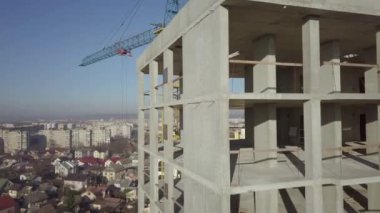 Bir şehirde inşaat halindeki yüksek apartmanın beton çerçevesinin havadan görünüşü.