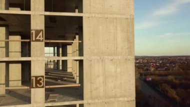 Bir şehirde inşaat halindeki tamamlanmamış uzun apartmanın beton çerçevesinin havadan görüntüsü..