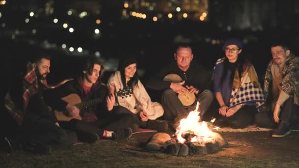 Grupo Pessoas Divertindo Sentadas Perto Fogueira Livre Noite Tocando Guitarra — Vídeo de Stock