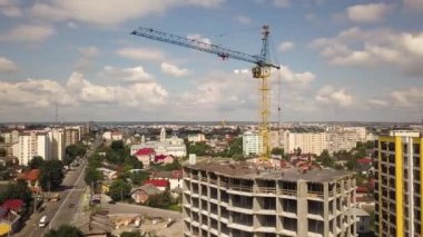 Bir şehirde inşaat halindeki yüksek apartmanın beton çerçevesinin havadan görünüşü.