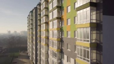 Birçok pencere ve balkonu olan yüksek bir apartman dairesinin hava görüntüleri..