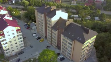 Yeşil yerleşim alanındaki çok katlı apartmanın havadan görünüşü.