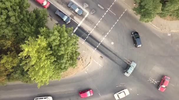 道路の交差点で通りに移動する車で街の交通の空中ビューをトップダウン — ストック動画