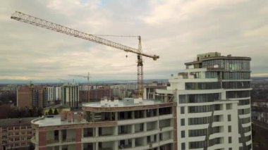 Daire ya da ofis yüksek binası yapım aşamasında. Tuğla duvarlar, cam pencereler, iskeleler ve beton destek sütunları. Parlak mavi gökyüzü arkaplanındaki kule vinci kopyala.