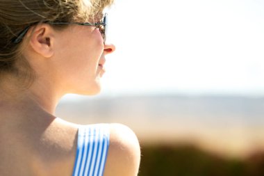 Açık havada mavi elbiseli ve güneş gözlüklü genç bayana yakın durun..