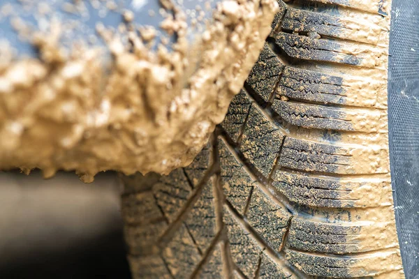 黄色の泥で覆われたゴムタイヤと汚れた車のホイールの閉じる — ストック写真