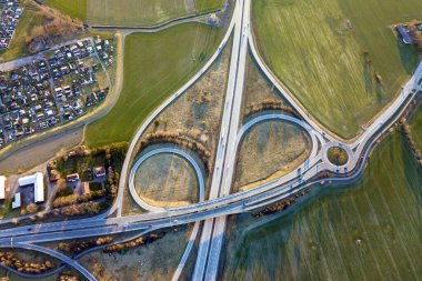 Modern karayolu yol kavşağının hava üst görünümü, Bahar yeşil alan arka planda ev çatıları. Drone fotoğrafçılığı.