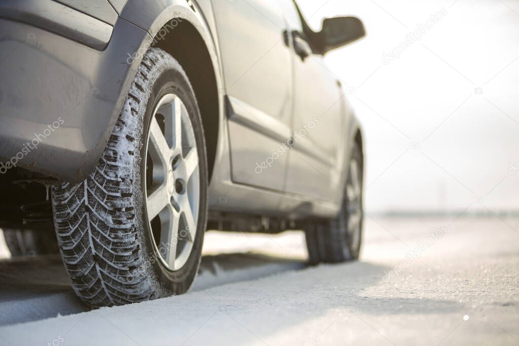 Close-up of car wheels rubber tire in deep snow. Transportation and safety concept.