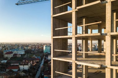 Bir şehirde inşaat halindeki yüksek apartmanın beton çerçevesinin havadan görünüşü.