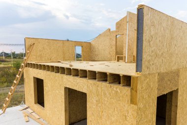 Yeni ve modern modüler evin inşaatı. İçinde köpük yalıtım malzemesi olan kompozit ahşap panellerden yapılmış duvarlar. Yeni enerji tasarruflu ev kavramı oluşturuluyor.
