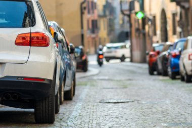 Şehir caddesinin kenarına park edilmiş modern arabalar var. Kaldırımın kenarına park edilmiş parlak araçlar. Kentsel ulaşım altyapı kavramı.