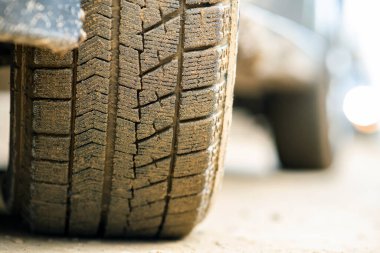 Lastik lastikli, sarı çamurla kaplı kirli araba tekerleğini kapat..