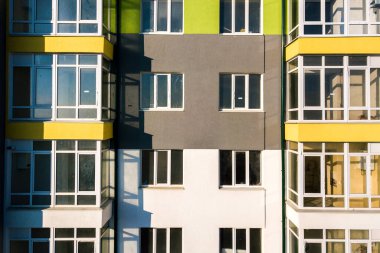 Birçok pencere ve balkonu olan yüksek bir apartman dairesinin havadan görünüşü.