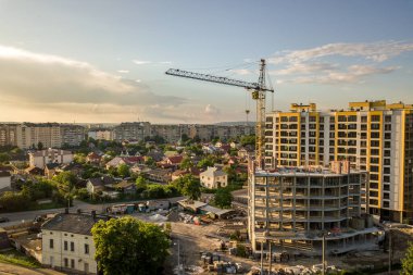 Daire ya da ofis yüksek binası yapım aşamasında. Tuğla duvarlar, cam pencereler, iskeleler ve beton destek sütunları. Parlak mavi gökyüzü arkaplanındaki kule vinci kopyala.