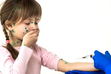 Doktor, suçiçeği, kızamık ya da kızamık virüsü kapmış korkmuş bir çocuğa aşı yapıyor. Okul konseptinde çocukların aşılanması.