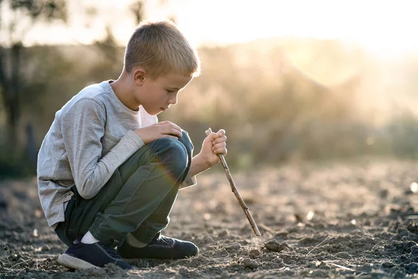 Çocuk Tahta Sopayla Oynuyor Dışarıdaki Siyah Toprağı Kazıyor — Stok fotoğraf