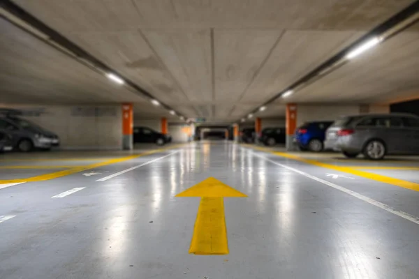 閉鎖地下駐車場内に停まっているぼやけた現代的な車と黄色のマーキング — ストック写真