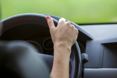 Bir araba sürüş direksiyonuna kadın eller.