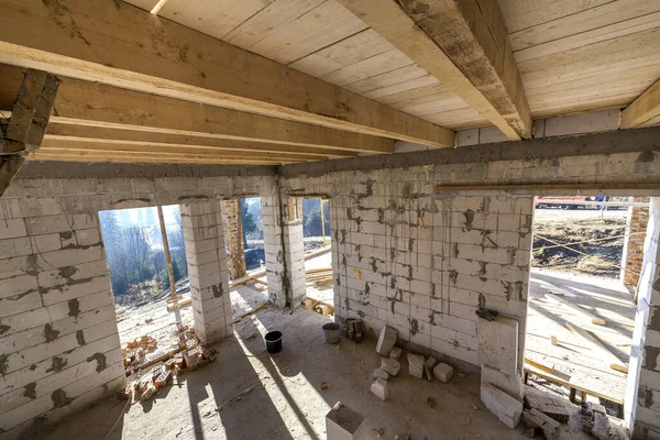 House room interior under construction and renovation. Energy saving walls of hollow foam insulation blocks, wooden ceiling beams and roof frame.