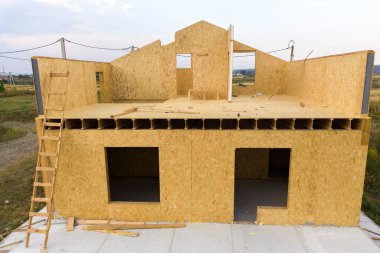 Yeni ve modern modüler evin inşaatı. İçinde köpük yalıtım malzemesi olan kompozit ahşap panellerden yapılmış duvarlar. Yeni enerji tasarruflu ev kavramı oluşturuluyor.
