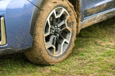 Lastik lastikli, sarı çamurla kaplı kirli araba tekerleğini kapat..