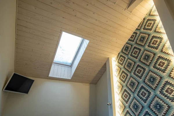 Wooden ceiling in a contemporary mansard room with attic window of decorative planks surface. — Stock Image Wooden Ceiling Contemporary Mansard Room Attic Window Decorative Planks Surface Royalty Free Stock Photos