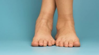 Mavi arka planda çıplak çocuk ayaklarını kapat.