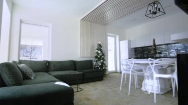 Beyaz duvarları, dekoratif ahşap elementleri, modern mobilyaları ve büyük yumuşak kanepesi olan modern ferah mutfağın içi..