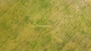 Yeşil çimenler ve su püskürten fıskiyelerle kaplı futbol sahası yüzeyinin yukarıdan görünüşü.