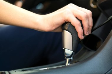 Otomatik vites kolunda elini tutan kadın sürücünün yakın çekim görüntüsü..