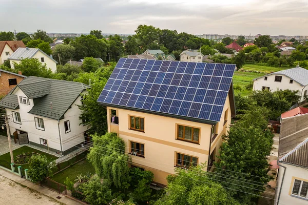 屋根の上に青色の光沢のある太陽光発電パネルシステムと新しい近代的な住宅のコテージの空中トップビュー 再生可能エネルギーグリーンエネルギー生産コンセプト — ストック写真