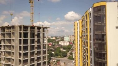Bir şehirde inşaat halindeki yüksek apartmanın beton çerçevesinin havadan görünüşü.