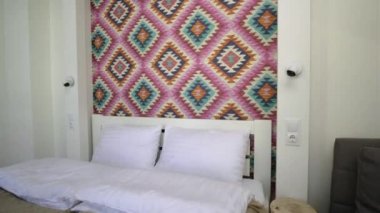 Çatı katında geniş bir otel odasının içinde büyük bir çift kişilik yatağın üzerinde temiz çarşaflar. Modern bir evdeki modern Mansard odası..