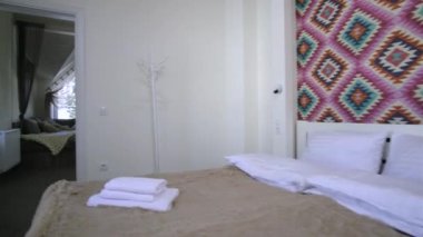 Çatı katında geniş bir otel odasının içinde büyük bir çift kişilik yatağın üzerinde temiz çarşaflar. Modern bir evdeki modern Mansard odası..