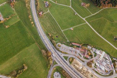 Kırsal alanda hareket halindeki trafik arabalarıyla otoyol üzerindeki hava manzarası.