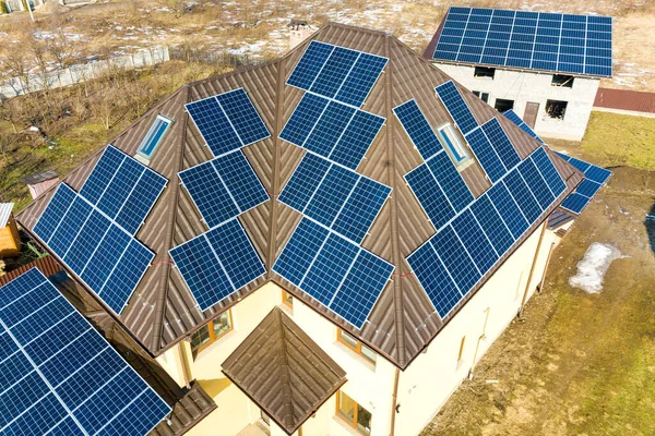 屋根の上に青色の光沢のある太陽光発電パネルシステムと新しい近代的な住宅のコテージの空中トップビュー 再生可能エネルギーグリーンエネルギー生産コンセプト — ストック写真