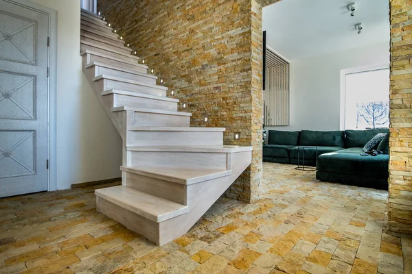 ロフトハウス内部のスタイリッシュな木製の現代的な階段 装飾的な石灰岩のレンガの壁と白いオークの階段を持つモダンな廊下 — ストック写真
