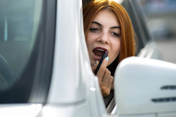 Closeup Young Redhead Woman Driver Correcting Her Makeup Dark Red — 스톡 사진