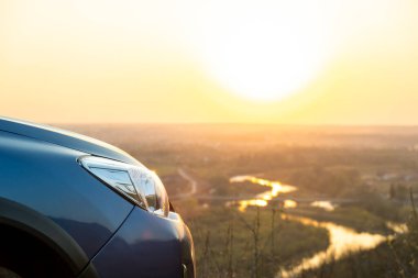 Günbatımında modern arabanın ön far lambasının detaylarını kapat..