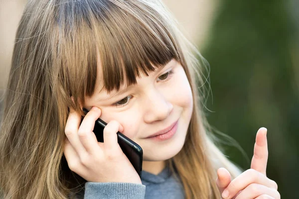 携帯電話で長い髪の少女の肖像画 小さな女性の子供がスマートフォンを使って通信しています 子どものコミュニケーションコンセプト — ストック写真