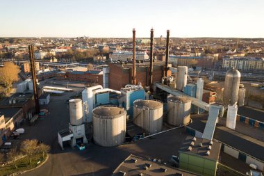 Petrol sanayi bölgesindeki büyük yakıt rezervlerinin ve petrol rafineri fabrikasının metal egzoz borularının havadan görünüşü.
